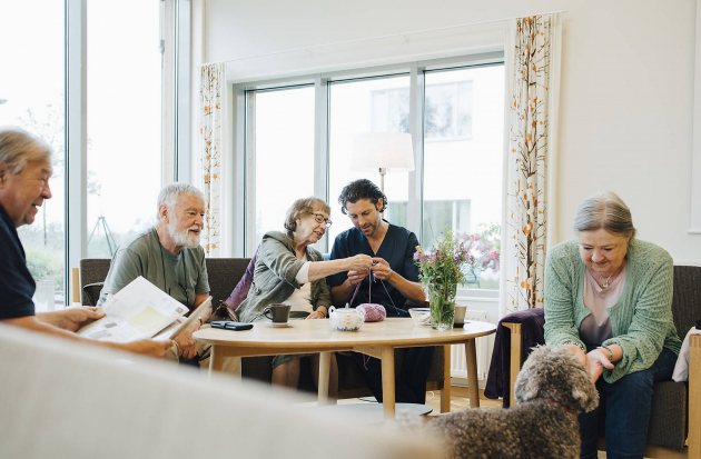 Huiskamer met diverse bewoners en verzorgenden