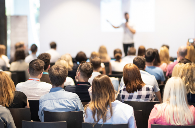 Zaal met mensen en presentatie