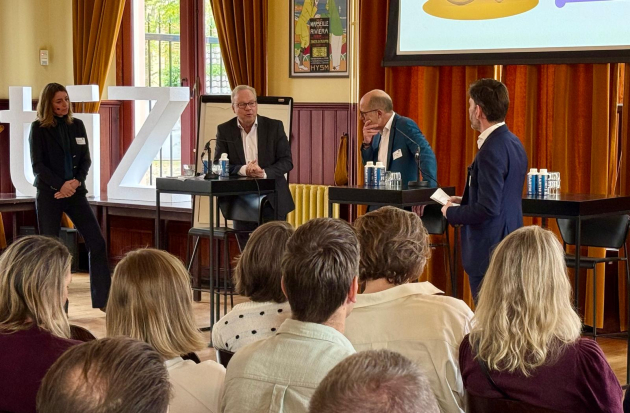 Foto van panelleden in gesprek tijdens het live event De hub naar huis