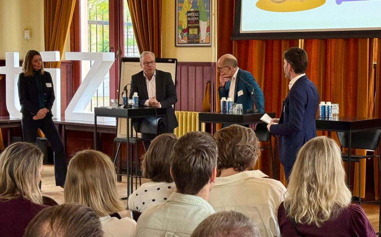 Foto van panelleden in gesprek tijdens het live event De hub naar huis