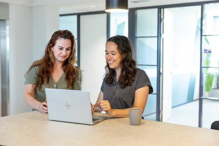 Twee collega's van ActitZ staan bij een laptop