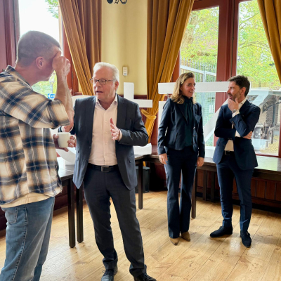 Joël Gijzen (CZ) praat na op het ActiZ live event Revalidatie & Herstel. Op de achtergrond spreekt Vivian Broex (Diaconessenhuis) met Rob Gruntjes (ActiZ)