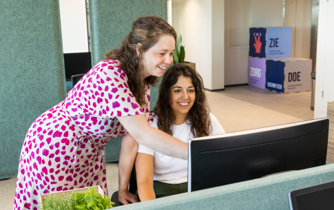 Twee collega's van ActiZ voor een computer scherm