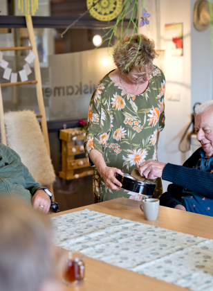 Bewoners drinken met elkaar koffie 