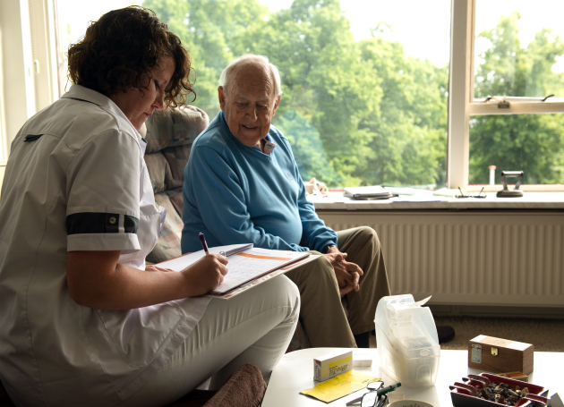 verpleegkundige in gesprek bij client thuis