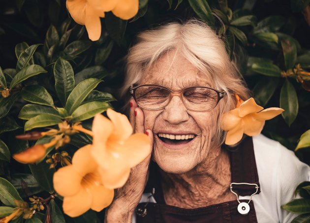 Oudere dame tussen de bloemen